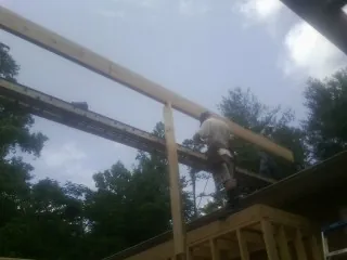 Carpenter setting a ridge beam over a new addition frame — Ice Dam Removal by Roofing Brothers in Matagorda