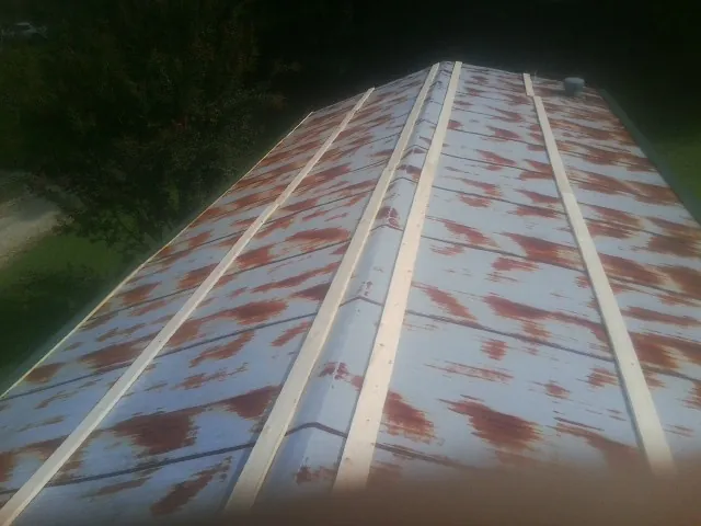 Rusted metal roof panels with new wood purlins before replacement — Storm Damage Roof Repair in Matagorda by Roofing Brothers