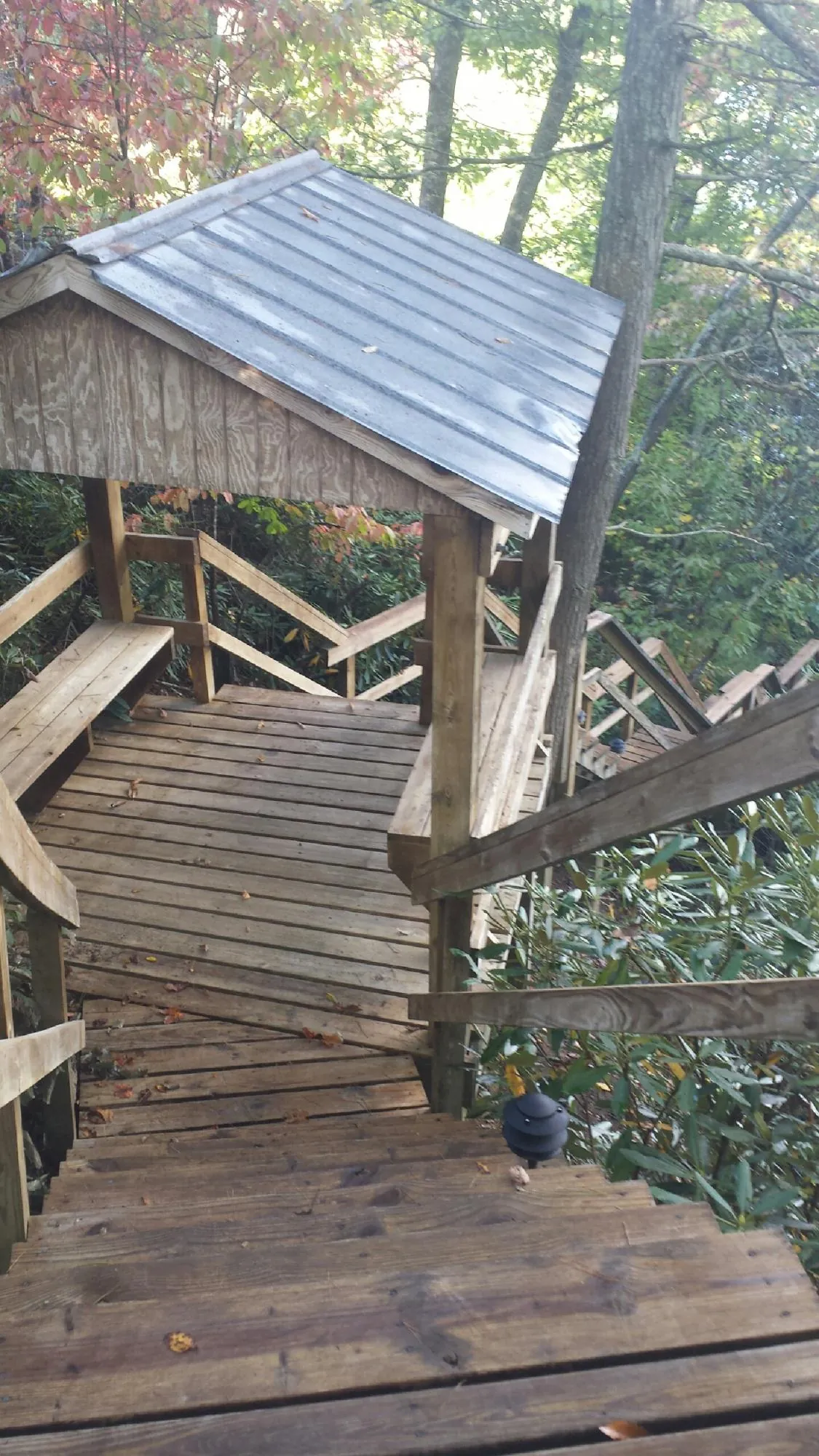 Metal roofed shelter over wooden steps on a wooded walkway — Skylight Repair & Installation work by our crew in Matagorda