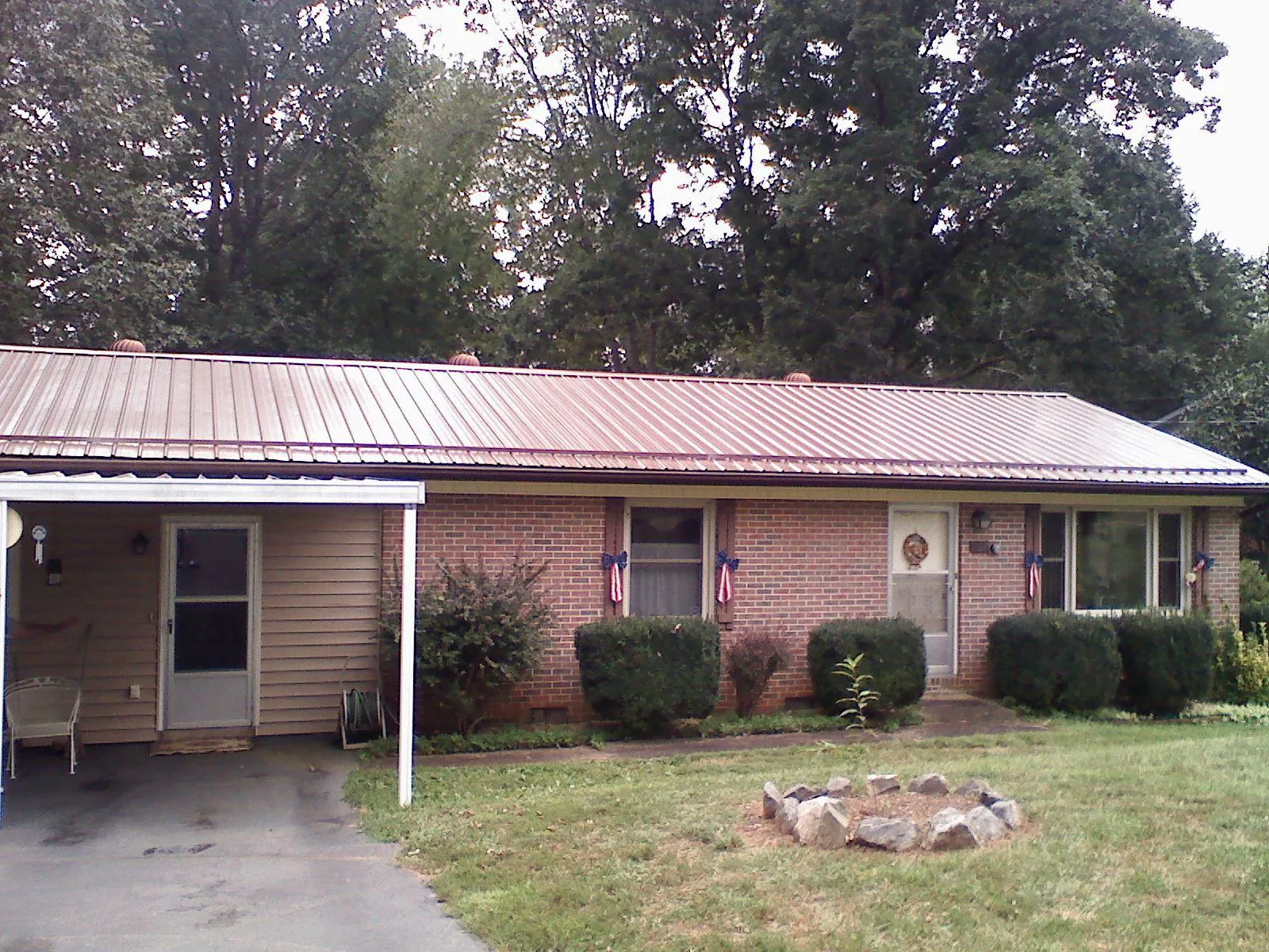 Bronze metal roof and carport on a brick ranch home — Roof Repair work by our crew in Matagorda