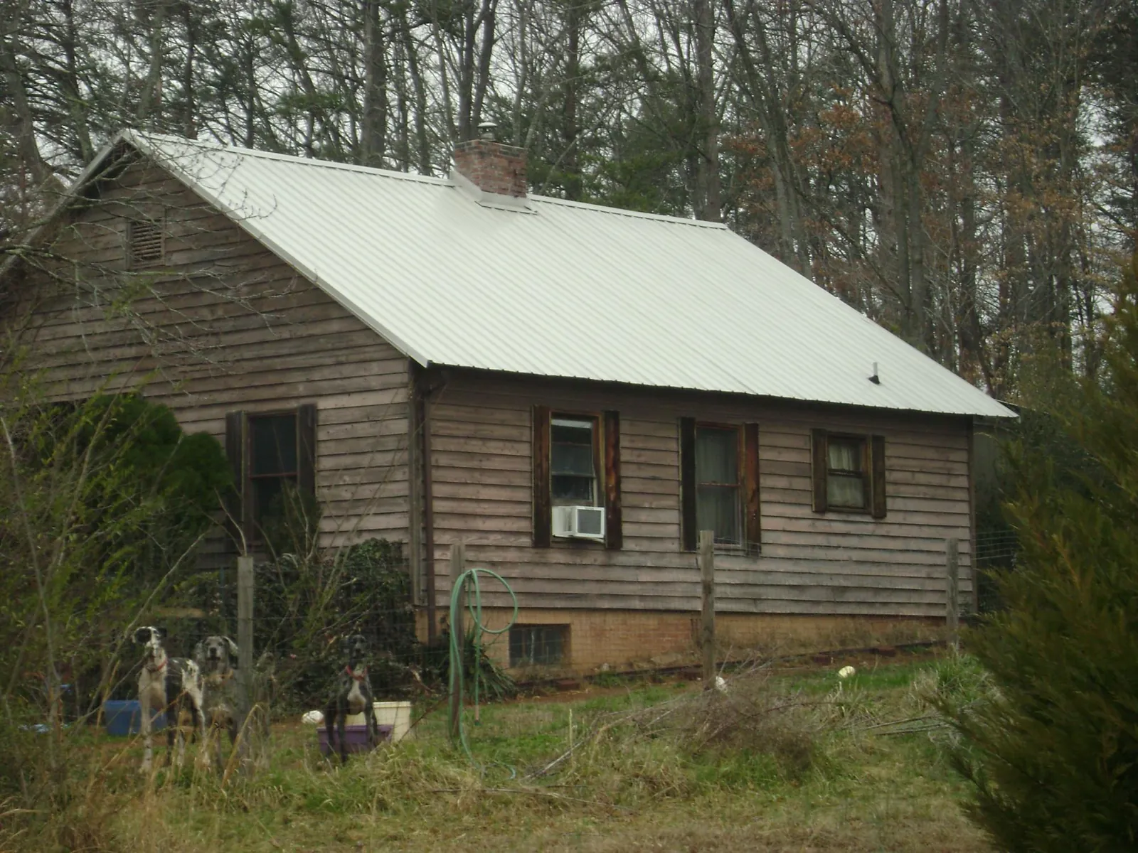 White metal roof on an old wood sided farmhouse, from a Metal Roof Installation job in Matagorda